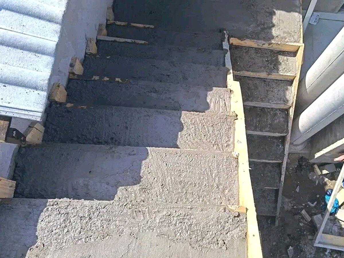 Concrete staircase construction with wooden formwork and wet cement